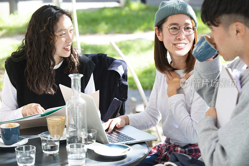 Three students studying at a café